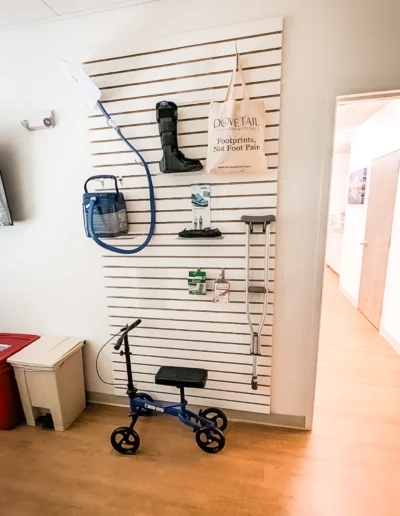 Dovetail Orthopedics patient product display wall with foldable scooter, crutches, dressings, legwalker boot, shoe lift, arctic flow and tote bag