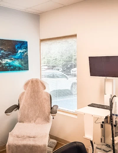 Landscape photo of Dovetail Orthopedics exam room with examination chair, monitor and wall art