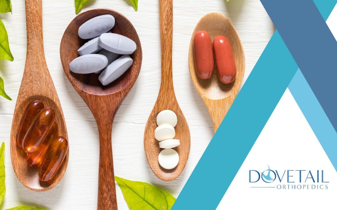 a variety of supplements arranged on wooden spoons against a clean, white background. There are four spoons, each holding a different type of supplement: capsules filled with a dark amber liquid, likely fish oil; grey-blue oval pills, possibly containing minerals; deep red capsules, which might be a type of antioxidant supplement; and small, white round tablets, commonly used for various dietary needs. On the right side of the image, there's a blue and white logo for "Dovetail Orthopedics," suggesting a focus on orthopedic health and wellness. This visual presentation effectively emphasizes natural health solutions and could be associated with a promotion or informational content related to dietary supplements in orthopedic care.